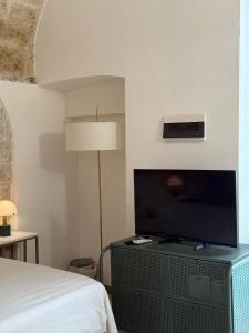 a bedroom with a bed and a flat screen tv at La Baita nel Borgo HOWME in Bari