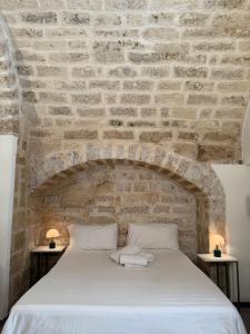 a bedroom with a brick wall with a bed at La Baita nel Borgo HOWME in Bari