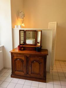 a wooden dresser with a mirror on top of it at Château de Courcelles in Équevilley