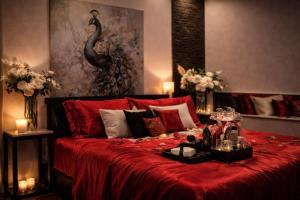 a bedroom with a bed with red sheets and candles at Bed & Wellness Angie in Almere +14 photos
