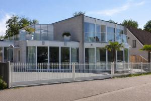 a house with a white fence in front of it at Bed & Wellness Angie in Almere
