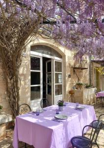 a table with a white table cloth and purple wisterias at Masseria Cianciò in Casa Serrafiori