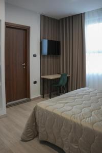 a bedroom with a bed and a table with a chair at Hotel La Casa Del Pellegrino in SantʼAnastasia