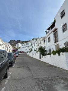 a city street with white buildings and parked cars at Casa Rural Hortensia in Zuheros