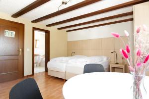 a bedroom with a bed and a table with chairs at La Collina Coliving and Coworking in Grächen