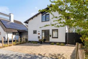 a white house with a driveway at Groenendijk Verhuur Vakantiewoning Casa Iris in Burgh Haamstede