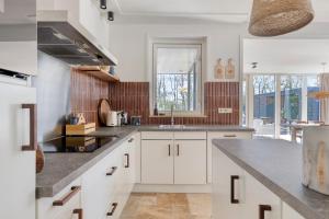 a kitchen with white cabinets and a counter top at Groenendijk Verhuur Vakantiewoning Casa Iris in Burgh Haamstede +22 photos