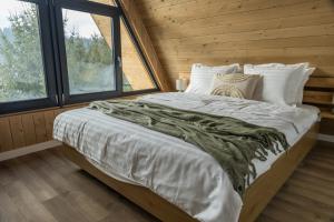 a large bed in a wooden room with a window at Le Cabane Retreat in Lereşti +44 photos