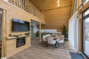 a dining room with a table and a fireplace at Le Cabane Retreat in Lereşti