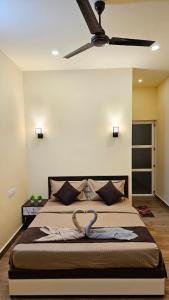 a bedroom with a bed with a ceiling fan at Grace place in Vagamon