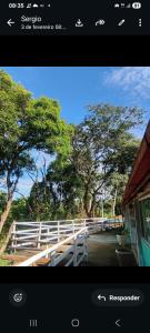 a picture of a white fence with trees in the background at Pousada Recanto Dos Pássaros in Colégio