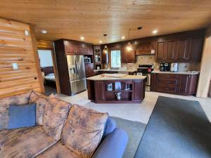 a living room with a couch and a kitchen at Waterfront with Spa - Etoile Filante in Saint Zenon +18 photos