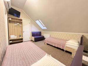 a bedroom with two beds and a blue chair at Готель Лаванда in Khmelnytskyi