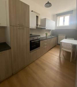 a kitchen with wooden cabinets and a table with a tableablish at HOMEY I Palazzo Venezian Apartments in Trieste