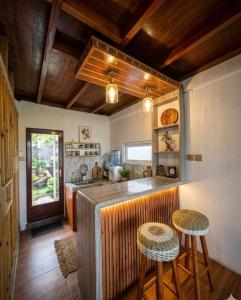 a kitchen with a counter and two stools at Villa Castanea Dieng in Diyeng
