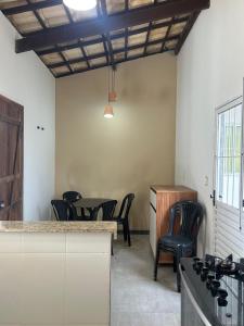 a room with chairs and a table and a kitchen at Casa Bella barra do Jacuípe in Camaçari