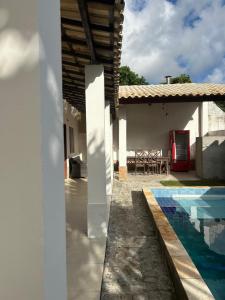 a house with a swimming pool next to a house at Casa Bella barra do Jacuípe in Camaçari