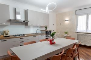a white kitchen with a white table and chairs at La Mia Reggia B&B in San Nicola La Strada
