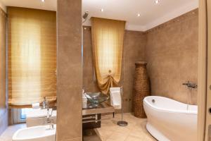 a bathroom with a tub and a sink and a bath tub at La Mia Reggia B&B in San Nicola La Strada