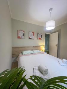 a bedroom with a white bed with a potted plant at 2BR Estoril Apartment - Near Estoril Beach & Cascais - Sleeps 4 in Estoril