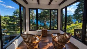 a room with four chairs and large windows at Лунен залив in Dospat +7 photos