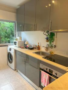 a kitchen with a sink and a washing machine at 2BR Estoril Apartment - Near Estoril Beach & Cascais - Sleeps 4 in Estoril +8 photos