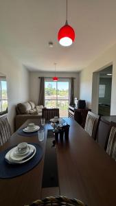 a living room with a dining room table with plates on it at Apartamento Melbela IV AP 41 in Espirito Santo Do Pinhal
