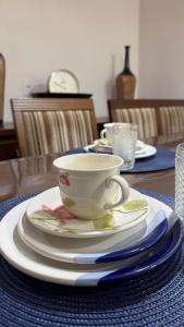 a table with a tea cup and plates on it at Apartamento Melbela IV AP 41 in Espirito Santo Do Pinhal
