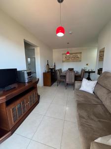 a living room with a couch and a tv at Apartamento Melbela IV AP 41 in Espirito Santo Do Pinhal