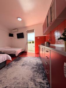 a kitchen with a sink and a bedroom with a bed at Apartmani Andrić - Stylish & Peaceful Apartment with Free Parking - 10 min Walk to Old Town in Trebinje