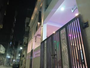 a building with a fence in a city at night at La vie Livings Only For Female in Noida