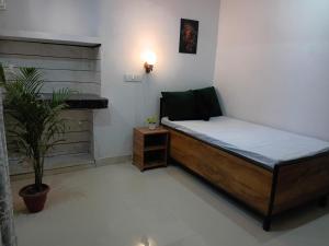 a small bedroom with a bed and a plant at La vie Livings Only For Female in Noida +12 photos