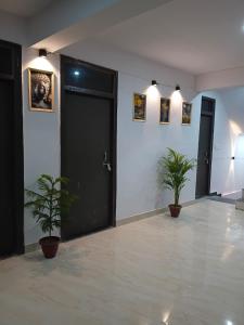 a room with a black door and two potted plants at La vie Livings Only For Female in Noida