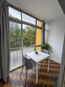 a white table and chairs in a room with a window at 2BR Estoril Apartment - Near Estoril Beach & Cascais - Sleeps 4 in Estoril