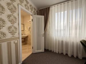 a bathroom with a door leading to a bathroom with a sink at Готель Лаванда in Khmelnytskyi