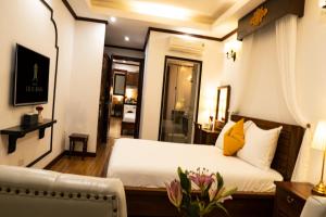 a bedroom with a white bed and a couch at Maison Julie Duong in Hanoi