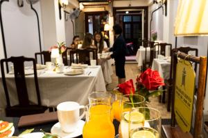 a table with glasses of orange juice on top of it at Maison Julie Duong in Hanoi
