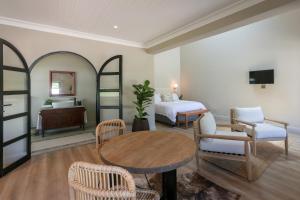 ein Schlafzimmer mit einem Bett, einem Tisch und Stühlen in der Unterkunft Hemelberg in Stellenbosch