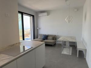 a kitchen and living room with a table and a couch at Villa Admare - LUX - minipiscina Spa vista mare - Spiaggia inclusa in Numana