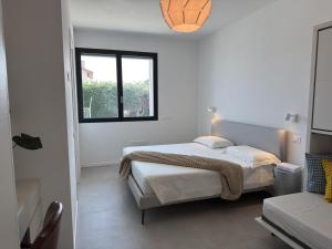 a white bedroom with two beds and a window at Villa Admare - LUX - minipiscina Spa vista mare - Spiaggia inclusa in Numana