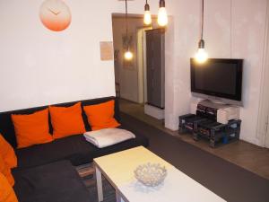 salon z czarną kanapą i telewizorem w obiekcie Box61 Art Concept Flat w Berlinie
