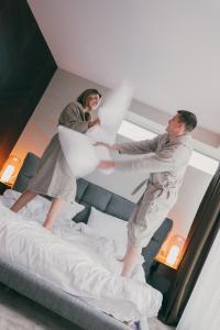 two men standing on top of a bed at Dunetton - self check-in hotel in Klaipėda +278 photos