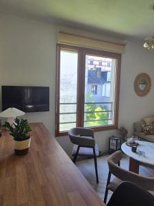 a living room with a table and a large window at Villa Sévigné in Nantes +2 photos