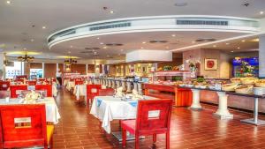 a restaurant with tables and red chairs and a buffet at بورتو مطروح - القبطان in Marsa Matruh