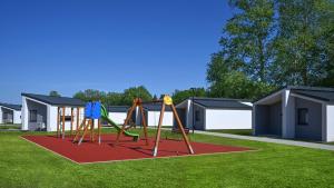 a playground with a swing set in a yard at AquaMed Hotel Harkány in Harkány
