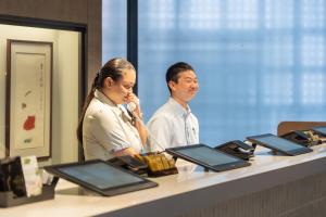 a man and a woman standing at a counter at Hotel Monterey La Soeur Naha in Naha