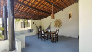 a dining room with a table and chairs at Country Club Pititinga in Pititinga