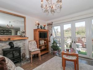 a living room with a fireplace and a mirror at 7 The Cedars in Wotton-under-Edge