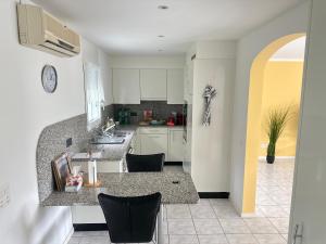 a kitchen with white cabinets and a counter top at HOLIDAY Residence Sette Nani in San Nazzaro