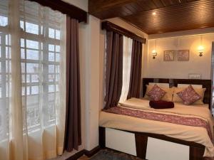a small bed in a room with a window at The Boho Darjeeling in Darjeeling